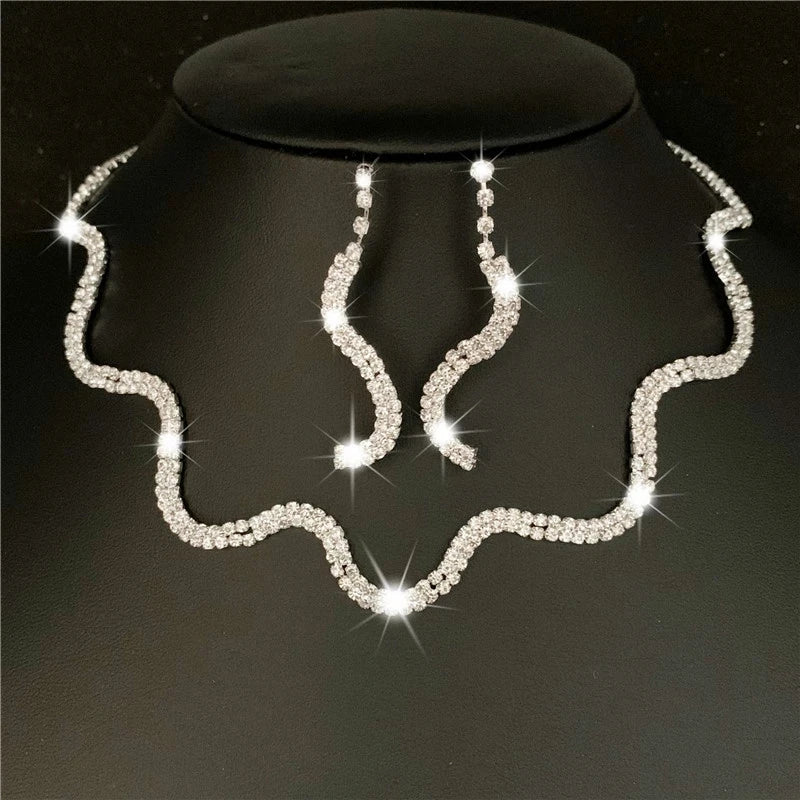 Silver jewelry set with necklace and earrings on a black stand