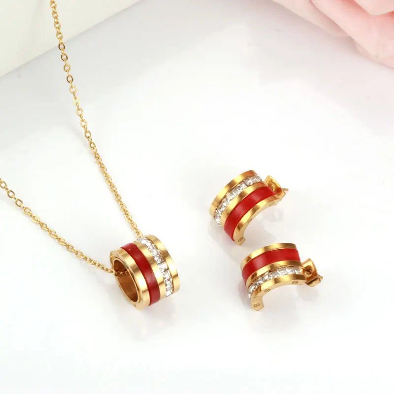 Gold and red earrings on a white background
