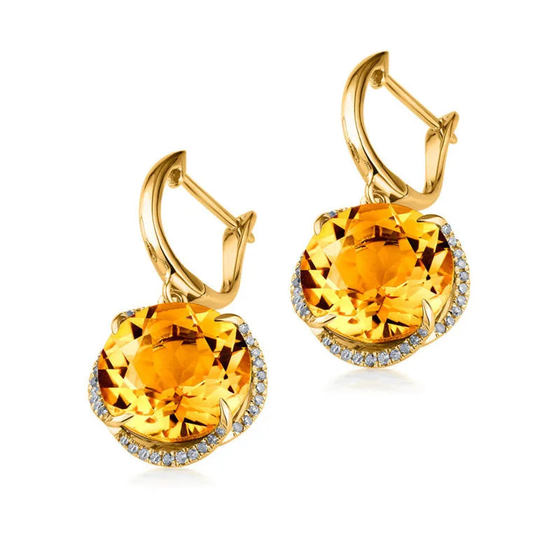 Gold earrings with large yellow gemstones on a white background