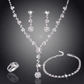 Silver jewelry set with necklace, earrings, ring, and bracelet on a dark background