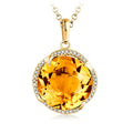 Gold pendant with a large yellow gemstone on a white background