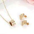 Gold and white jewelry set on a light background