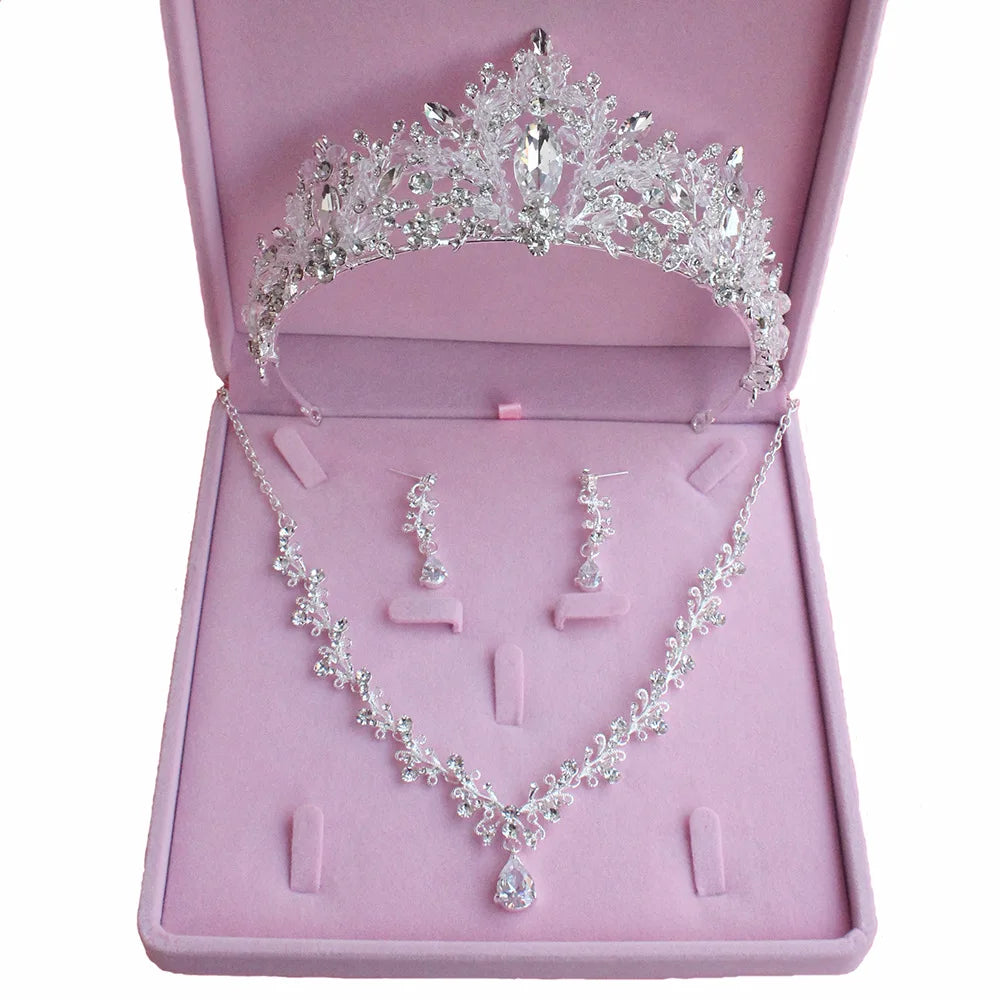Jewelry set with tiara, necklace, and earrings on a pink display box.