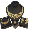 Gold jewelry set including necklace, bracelet, and earrings on black stands.