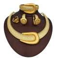 Gold jewelry set including necklace, bracelet, ring, and earrings on a brown stand.