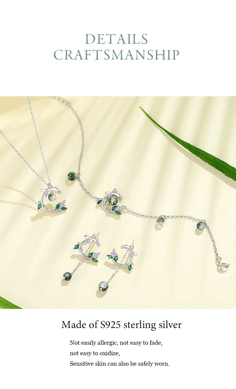 Silver jewelry set with green stones on a beige fabric background