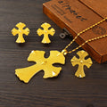 Gold cross-shaped jewelry set with a necklace on a wooden surface.