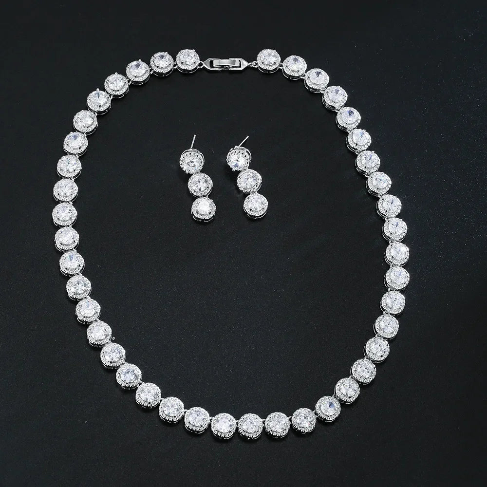 Silver necklace and earrings set on a black background