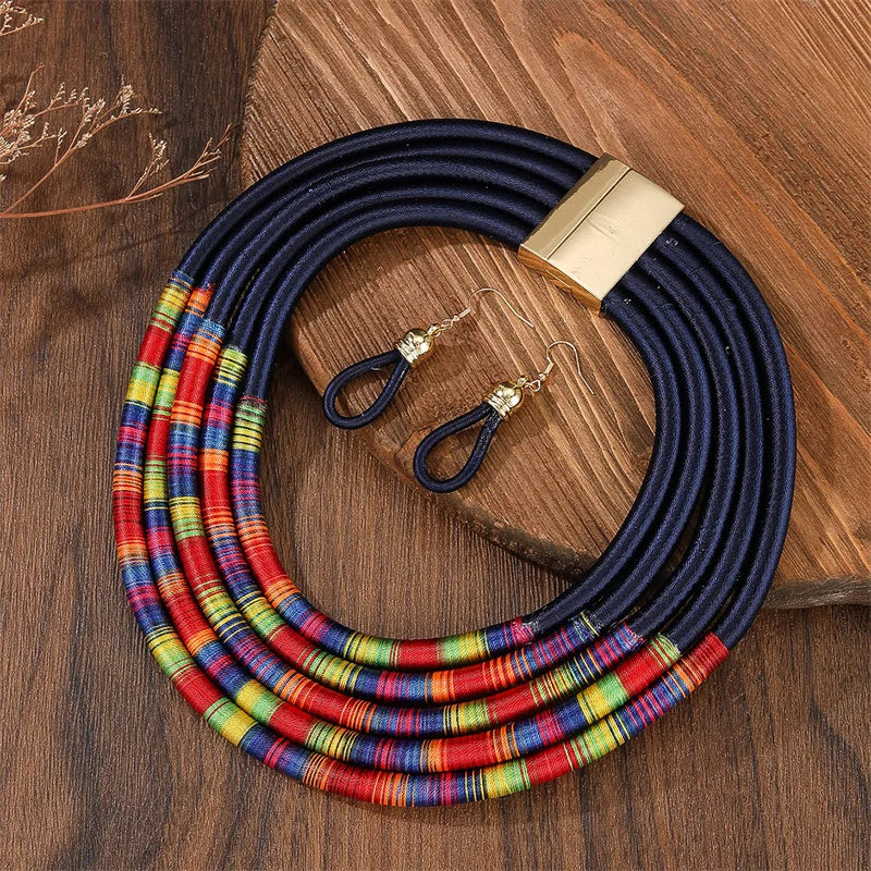 Colorful striped necklace with a gold clasp and matching earrings on a wooden surface.
