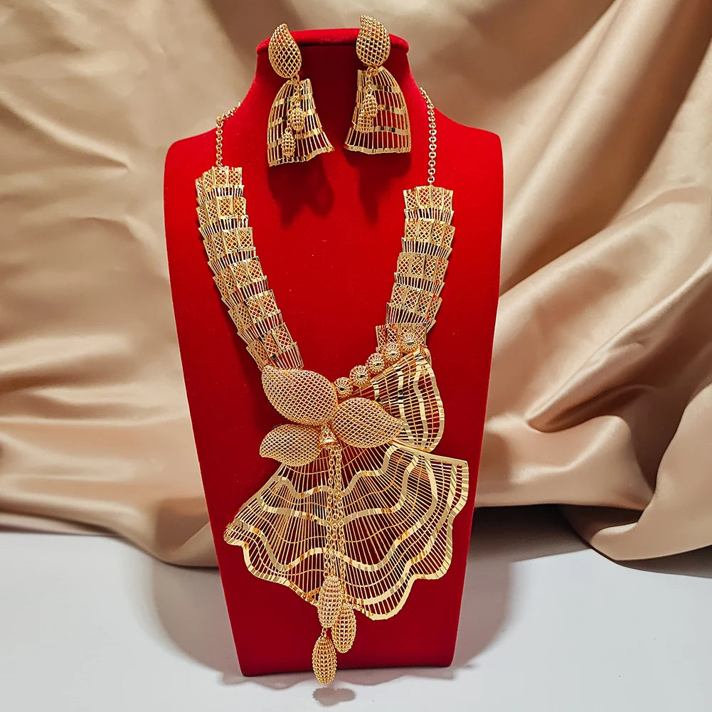 Gold necklace and earrings set on a red stand with a beige fabric background