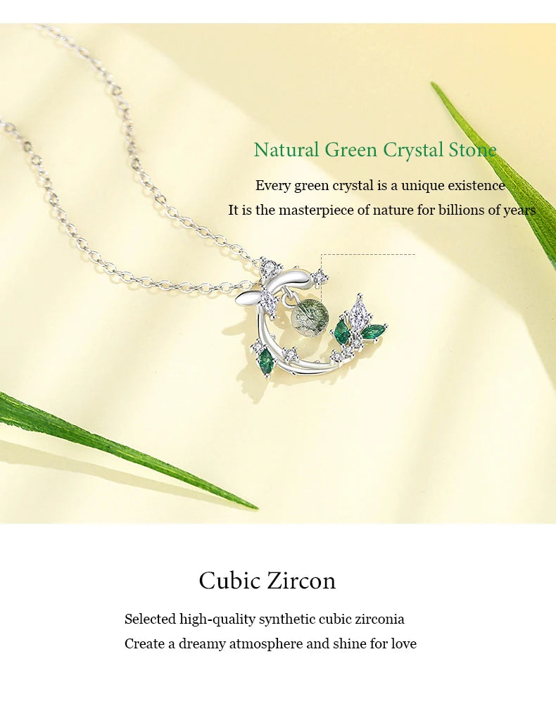 Silver necklace with green crystal pendant on a beige background