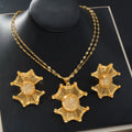 Gold necklace and earrings set on a black background