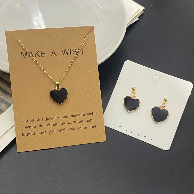 Heart-shaped jewelry set with necklace and earrings on display cards.