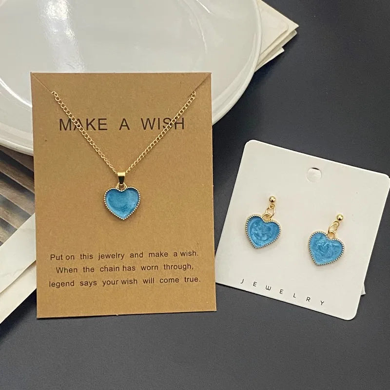 Jewelry set with heart-shaped blue pendant on cards with text