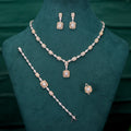 Jewelry set with necklace, bracelet, and earrings on a green stand.
