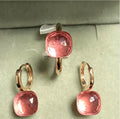Pair of pink gemstone earrings on a light green background