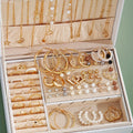 Jewelry organizer with gold and pearl necklaces, earrings, and bracelets.