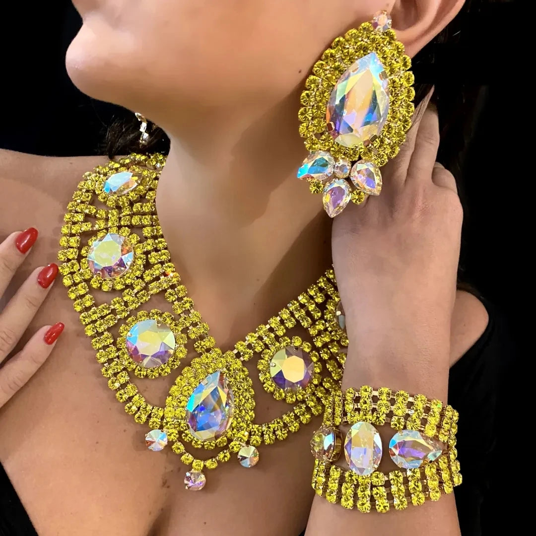 Close-up of a person wearing a yellow gemstone necklace, earrings, and bracelet.