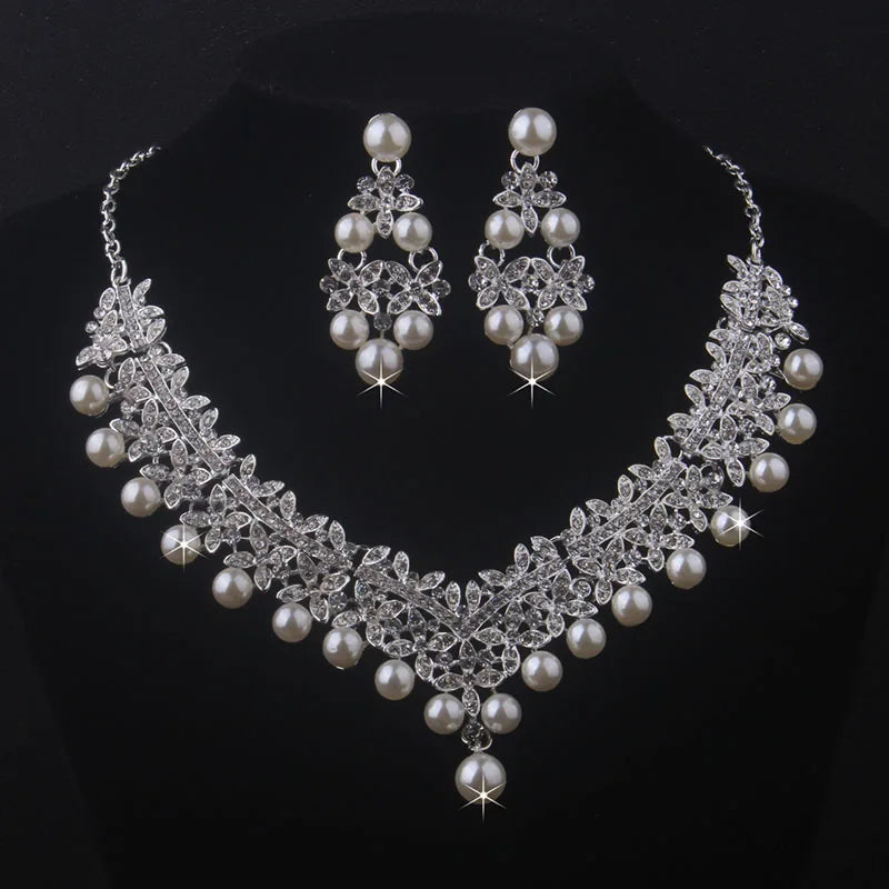 Pearl and crystal necklace and earrings set on a black background