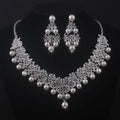 Pearl and crystal necklace and earrings set on a black background