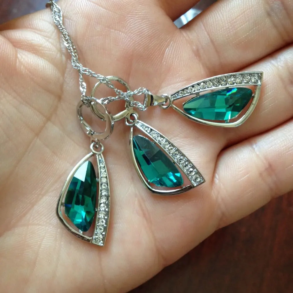 Jewelry with green teardrop pendants on a hand