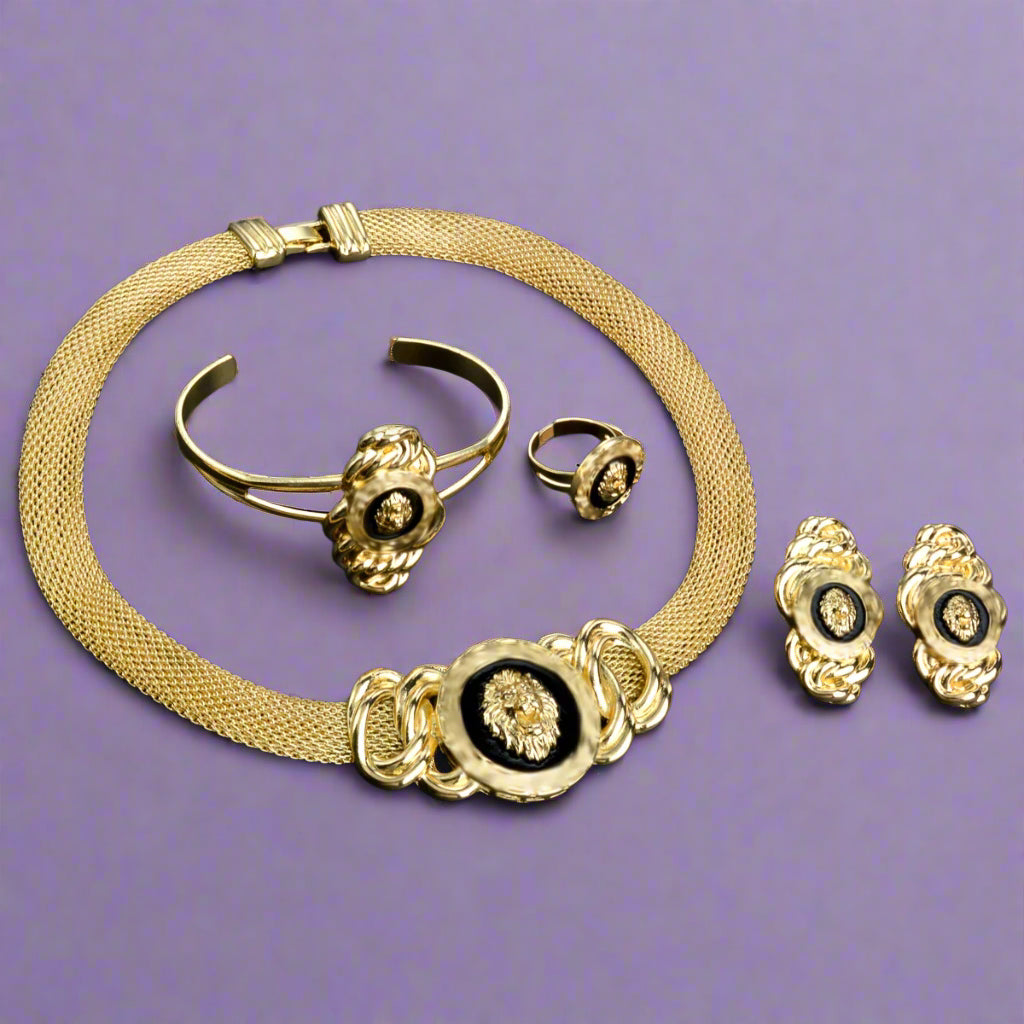 Gold jewelry set including necklace, bracelet, ring, and earrings on a violet background