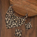 Leopard print necklace, earrings, and bracelet set on a wooden surface