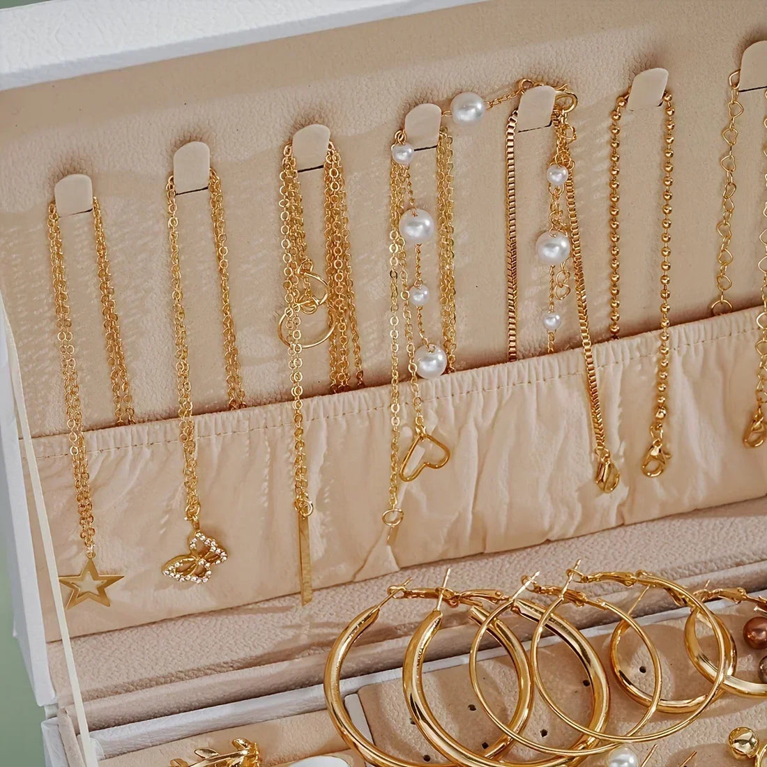 Jewelry set with necklaces, bracelets, and earrings in a display box on a blue background.