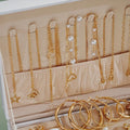 Gold necklaces and earrings displayed in an open jewelry box.