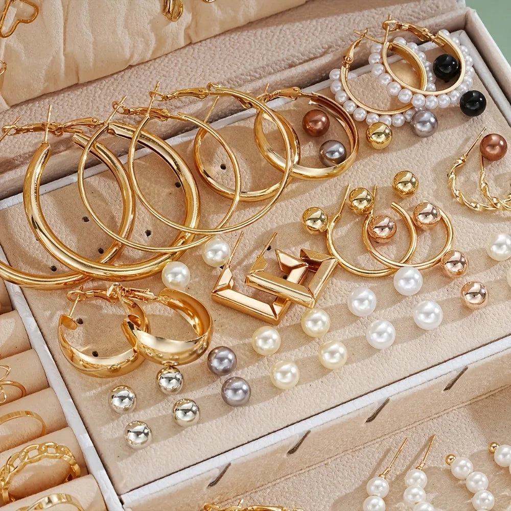 Assorted gold and pearl earrings in a jewelry box