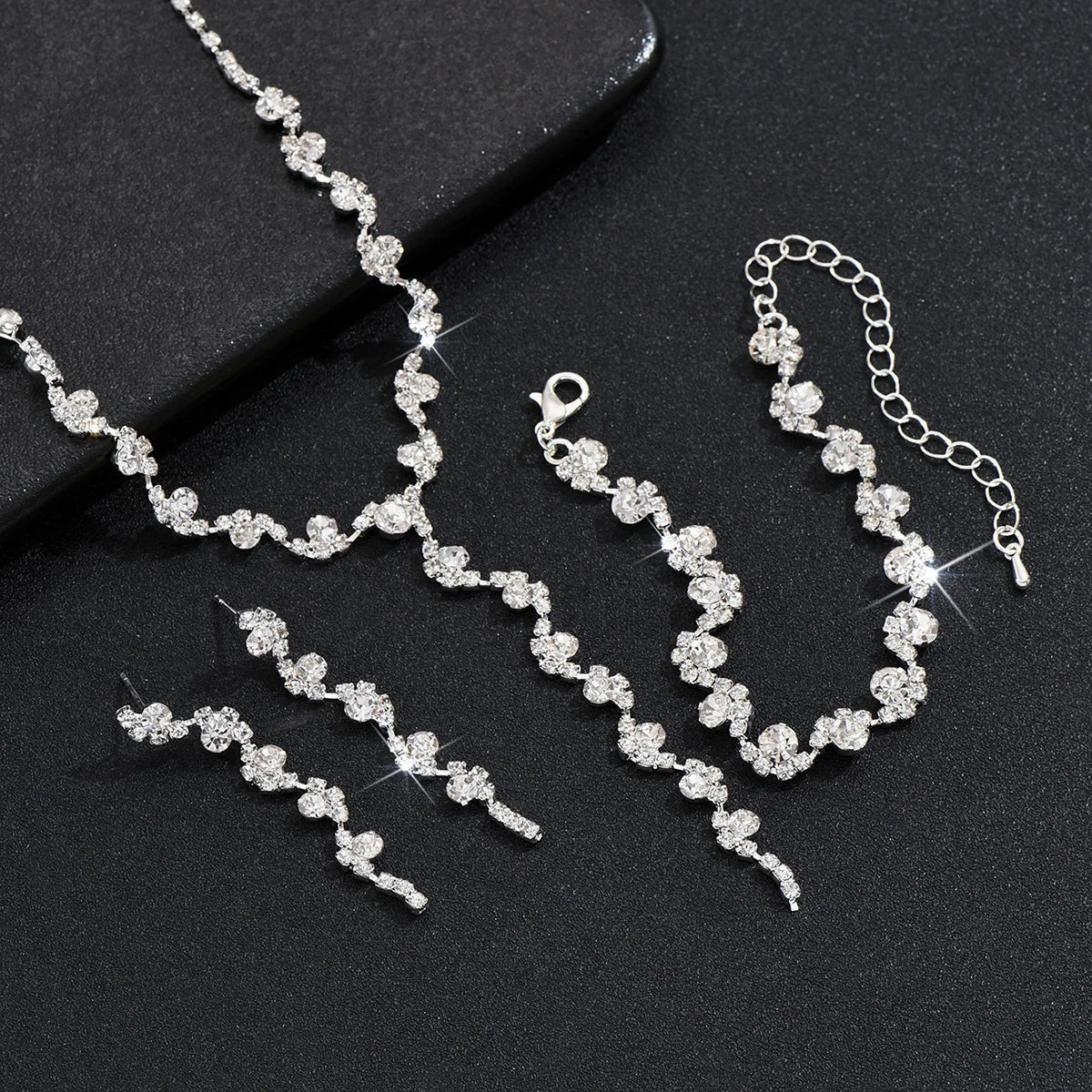 Silver jewelry set with necklace and bracelet on a black background
