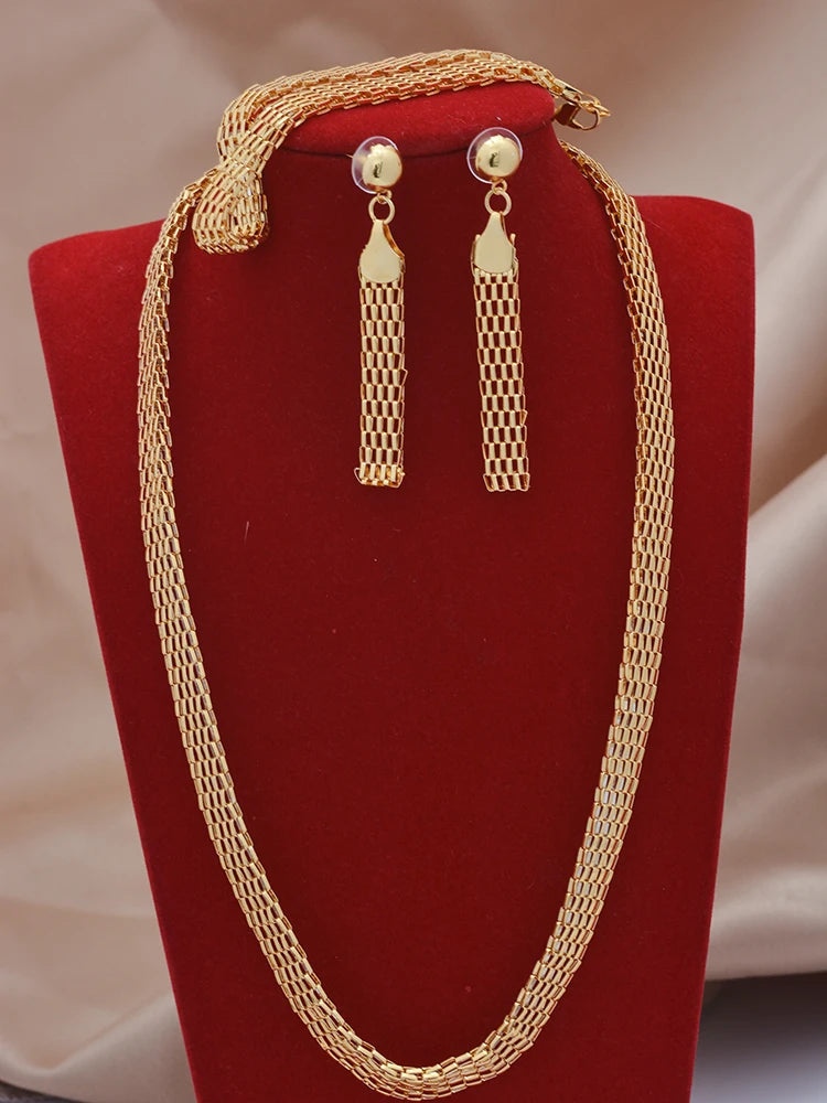 Gold necklace and earrings set on a red stand