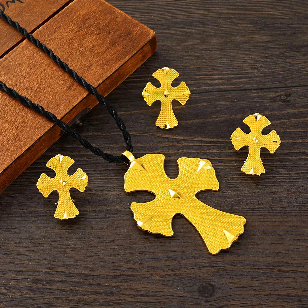 Gold cross-shaped pendant and necklace on a wooden surface