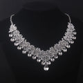 Silver necklace with clear crystals on a black background