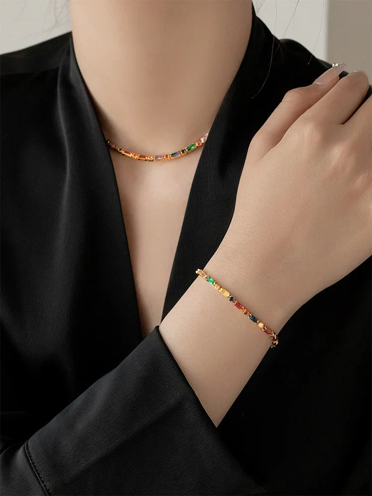 Colorful gemstone necklace and bracelet set on a beige surface with 'TAOYA' branding.