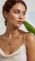 Woman wearing a necklace with a strawberry pendant, green parrot on shoulder, against a neutral background