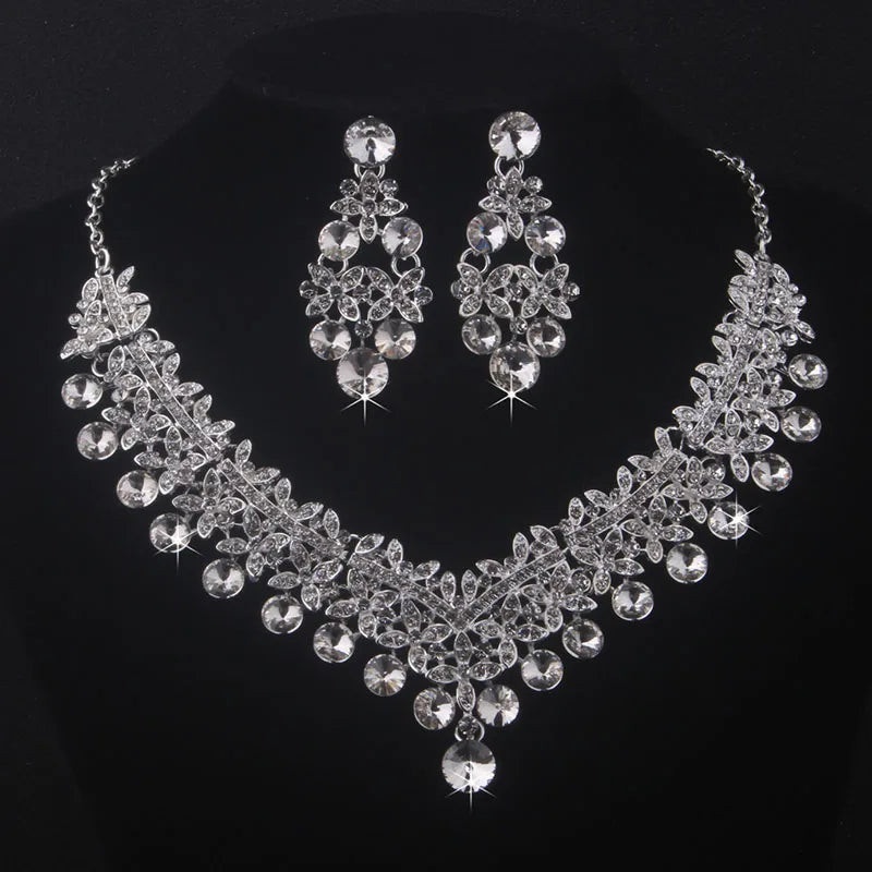 Pearl and crystal necklace and earrings set on a black background