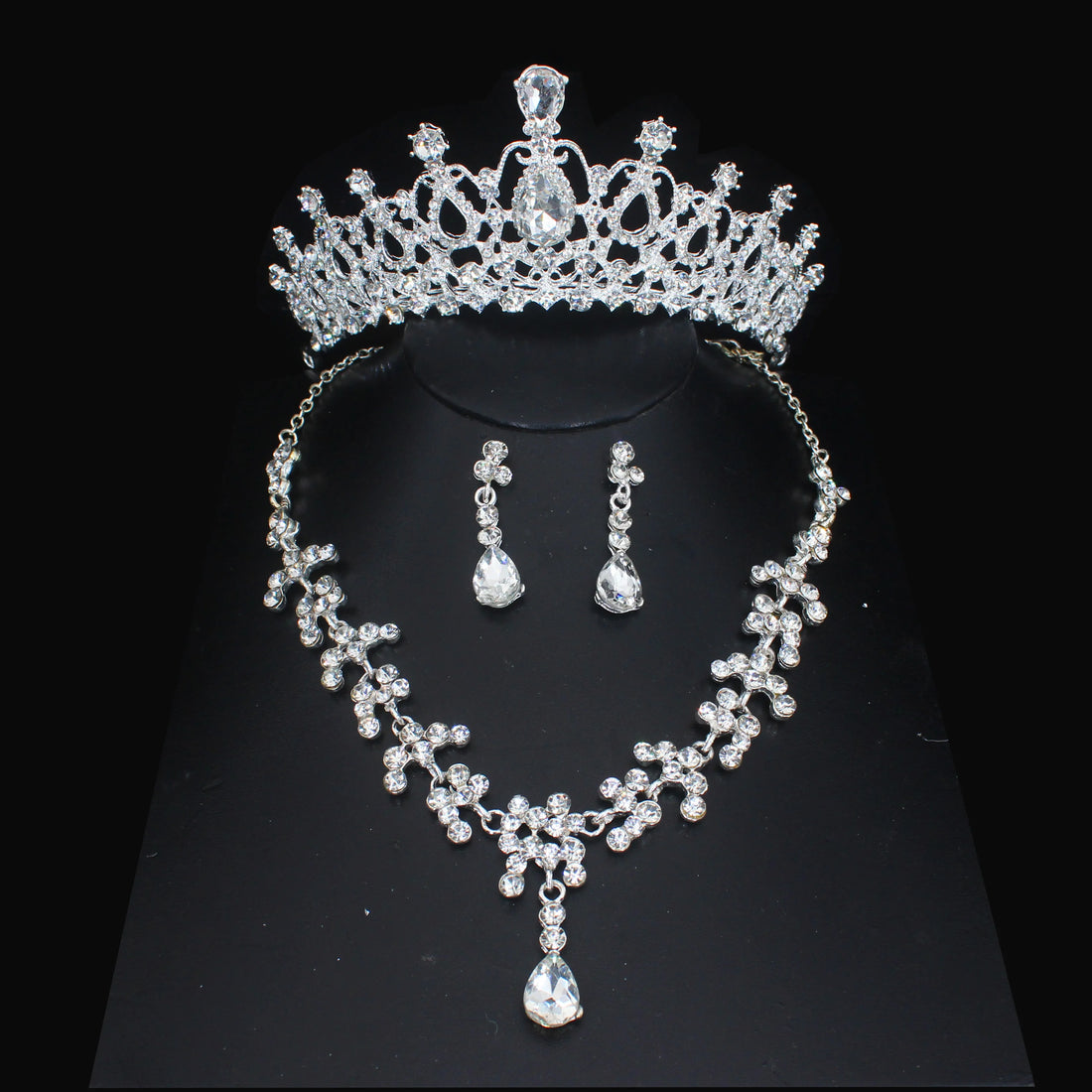 Purple gemstone tiara, necklace, and earrings set on a black background