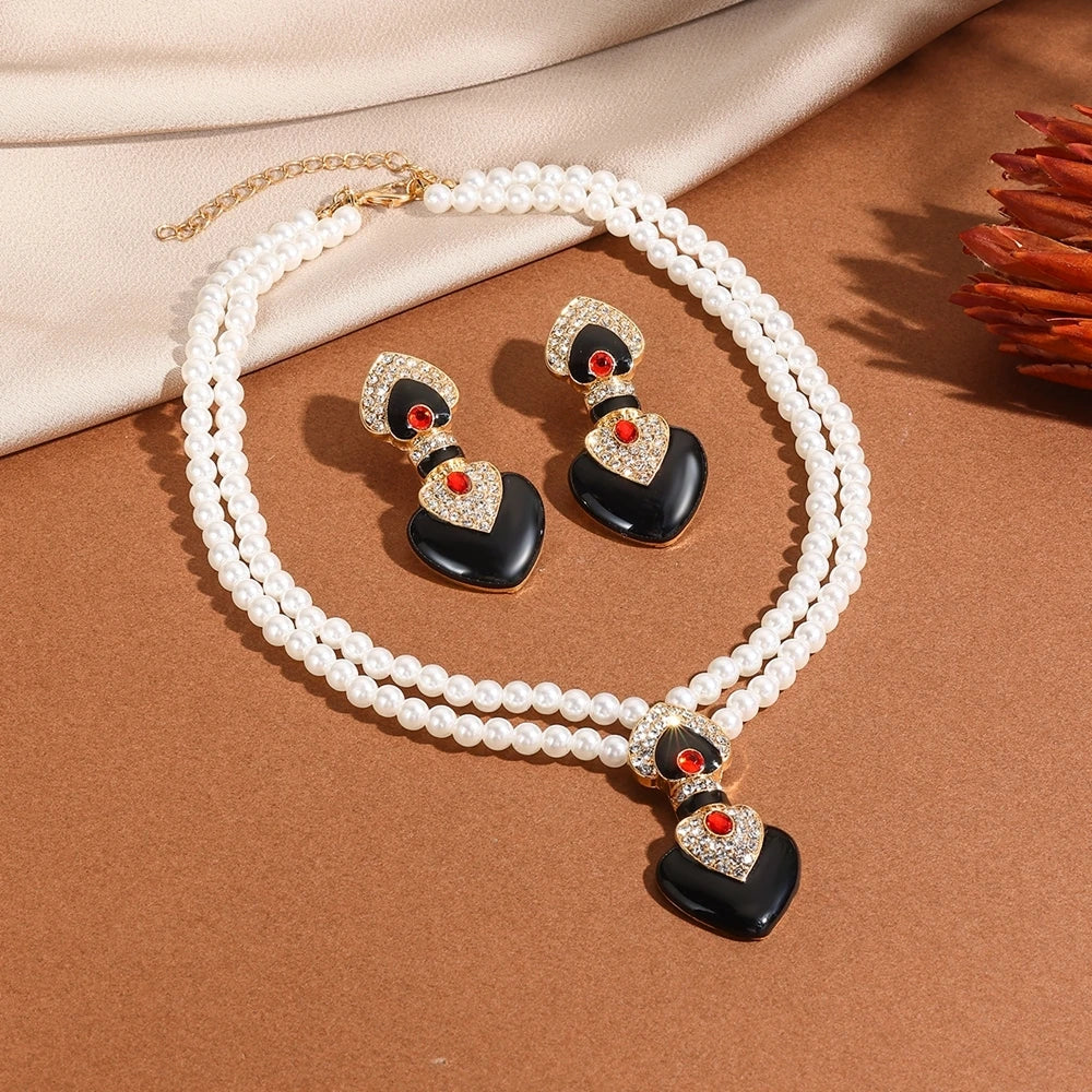 Pearl necklace with black and red heart-shaped pendants on a brown surface