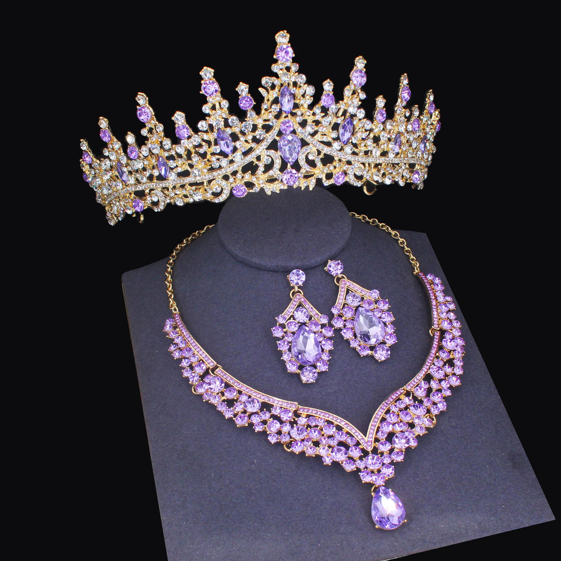 Purple gemstone tiara, necklace, and earrings set on a black background